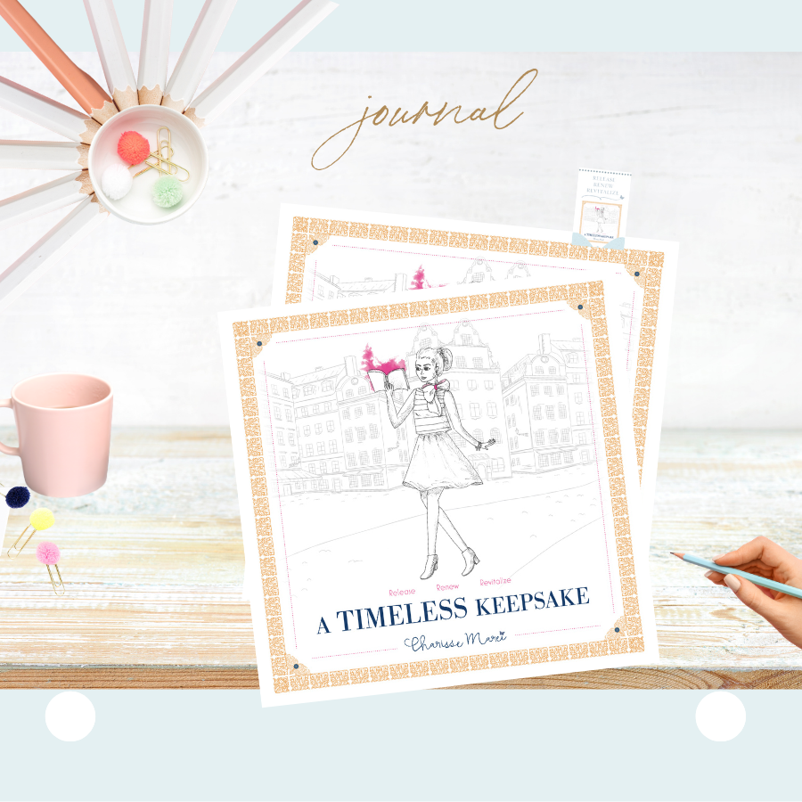 Two copies of A Timeless Keepsake sit on a bleached wood surface next to a pale pink mug, a hand holding a pale blue pencil reaching towards them. 